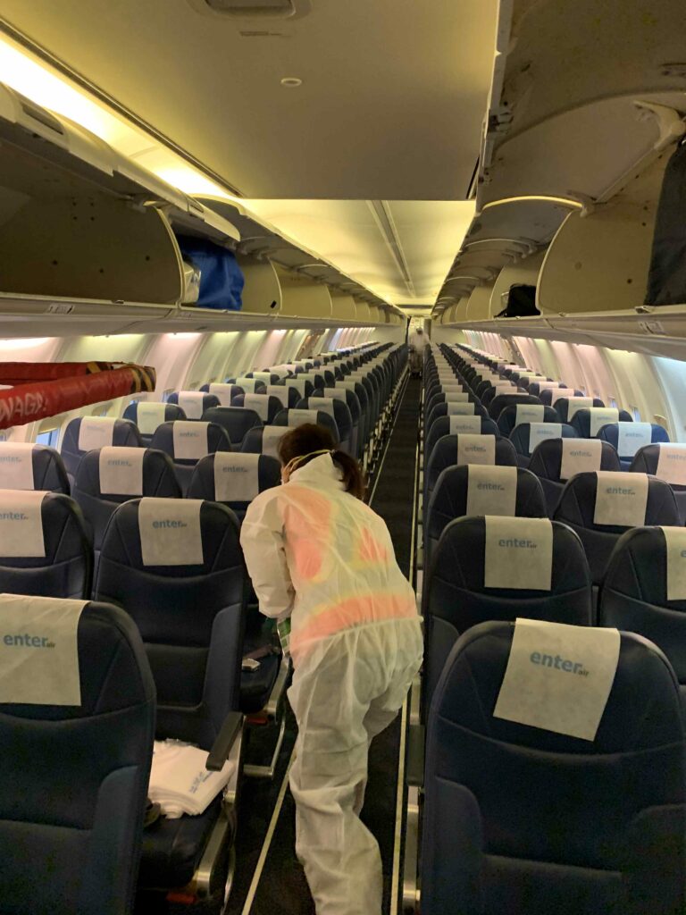 Woman sanitizing the airplane seats
