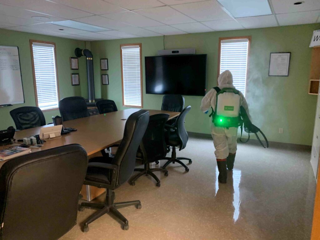Man sanitizing the conference room